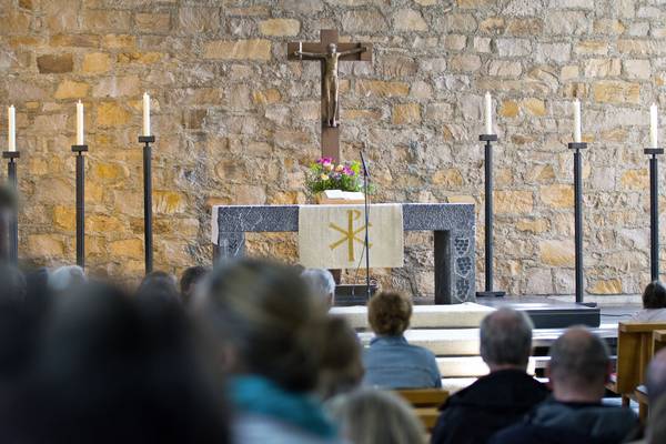 Quelle: Marian Nestmann / fundus-medien.de, Fundus, redaktionell frei verwendbar, 173 Gemeindegottesdienst in einer Kirche; im Vordergrund sitzt die versammelte Gemeinde, im Hintergrund stehen Altar, Kreuz und Kerzen vor einer Natursteinwand.